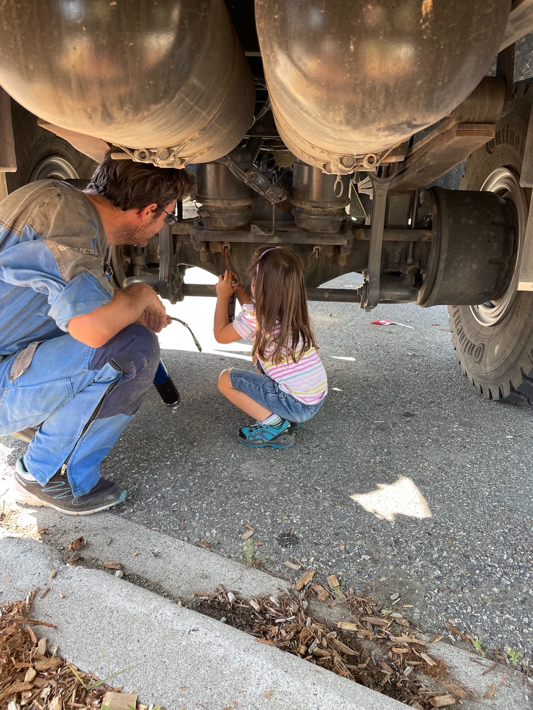 Father and small daughter doing maintenance underneath Coco