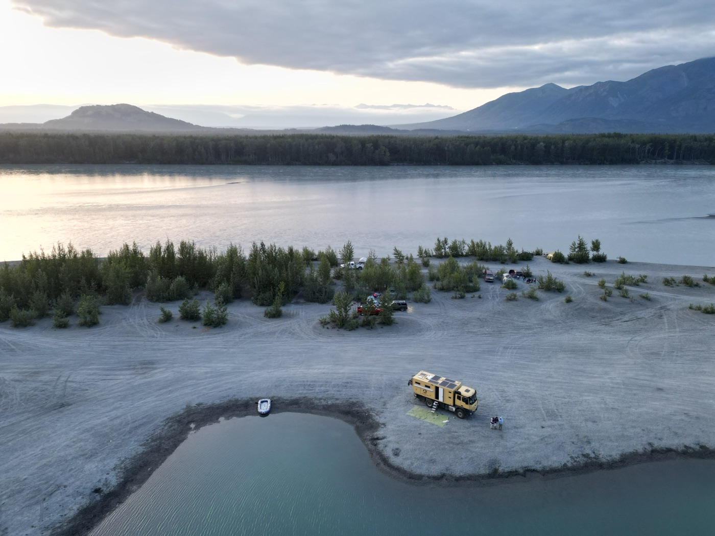 Coco camped on a riverside spit at sunset in the Yukon